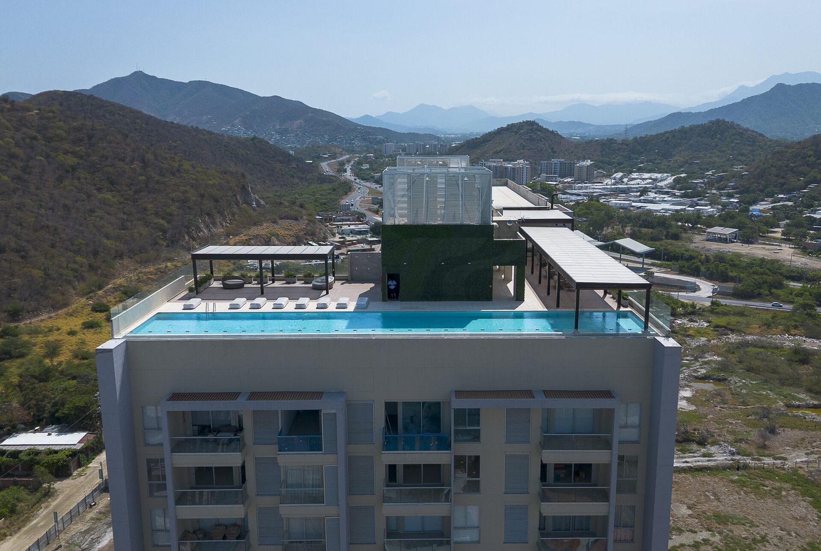 Aerial view of the Delventto rooftop with the infinity pool and mountains